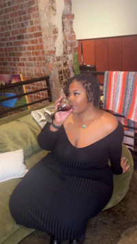 a woman sitting on a couch drinking wine